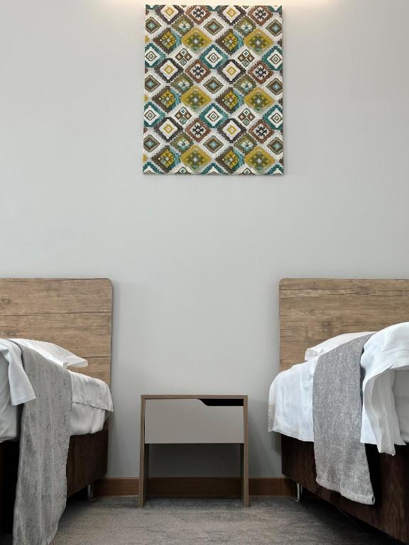 a room with two beds and a painting on the wall at PORT INN Hotel in Astana