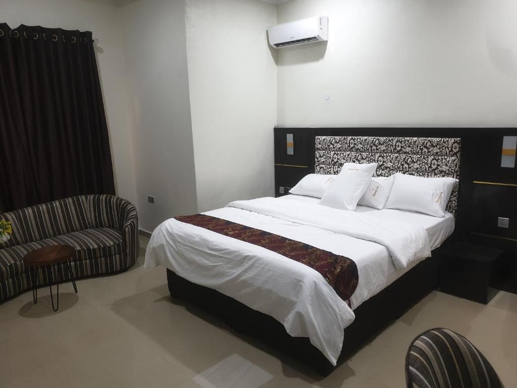 sypialnia z dużym łóżkiem i krzesłem w obiekcie Downunder suites w mieście Gwarinpa