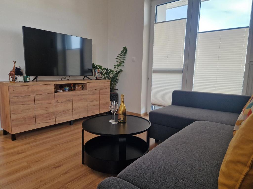 salon z telewizorem, kanapą i stołem w obiekcie Apartmán Jablone w mieście Bytča