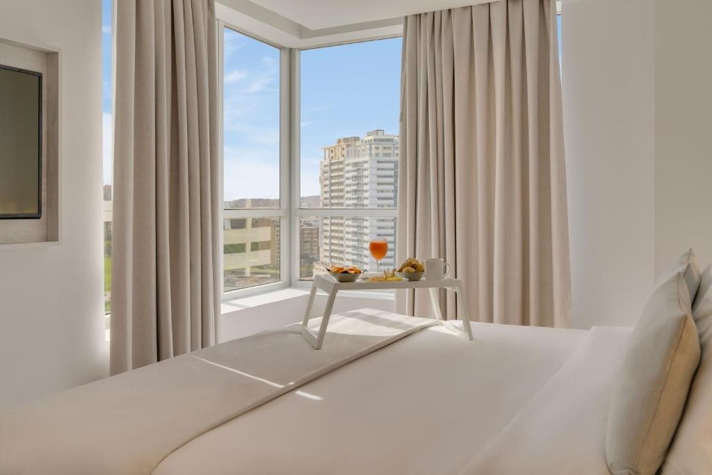 a bedroom with a bed and a large window at Pestana Tanger - City Center Hotel Suites & Apartments in Tangier