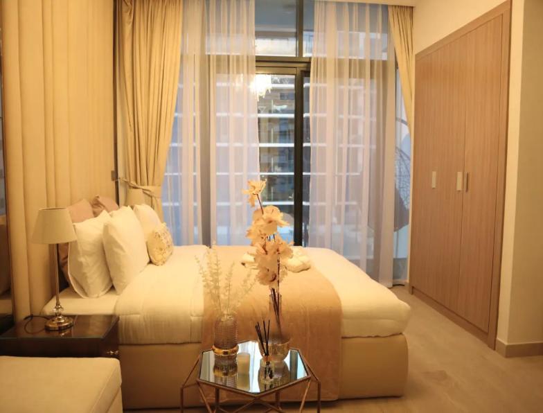 una habitación de hotel con una cama y una mesa con flores en Business Bay Stylish Apartment In Dubai en Dubái