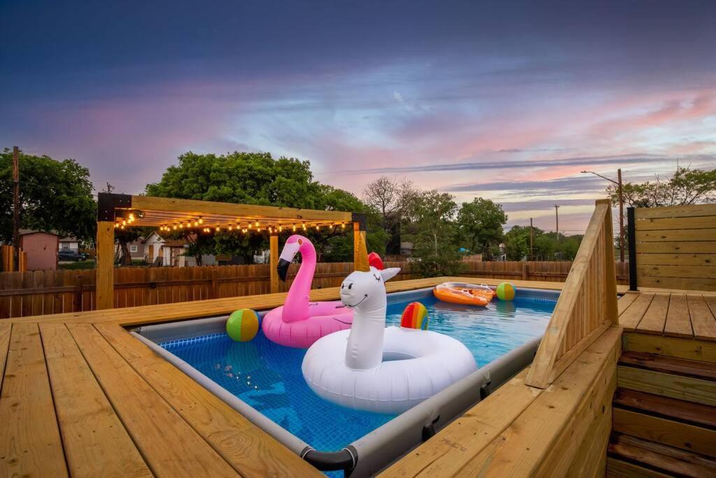a swimming pool with two inflatable swans and avisorangering at Pool-MovieTheater KING BED & 5 minutes to Alamodome in San Antonio