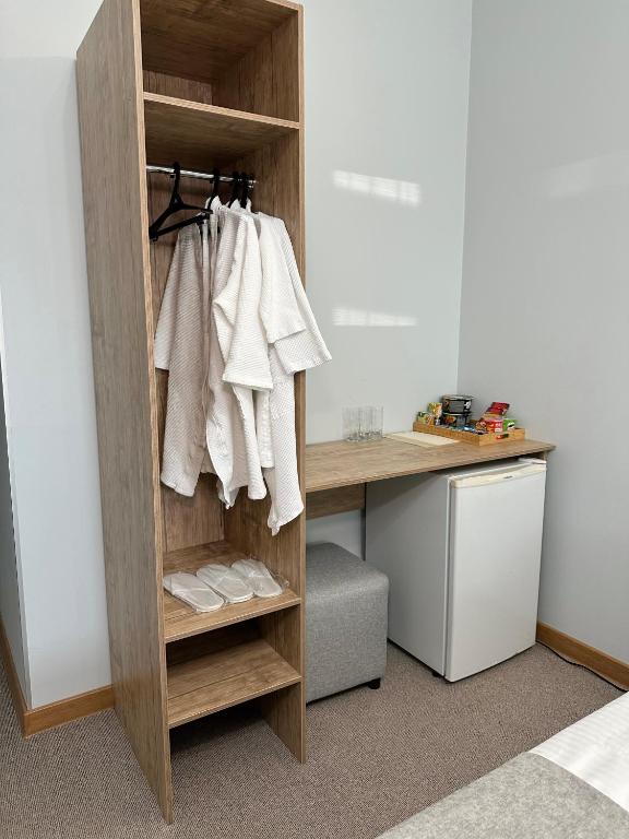 a wooden shelf with white towels on it next to a desk at PORT INN Hotel in Astana