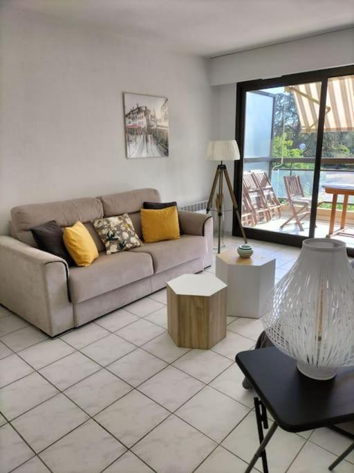 un salon avec un canapé et une table dans l'établissement Joli appartement avec piscine, à Antibes