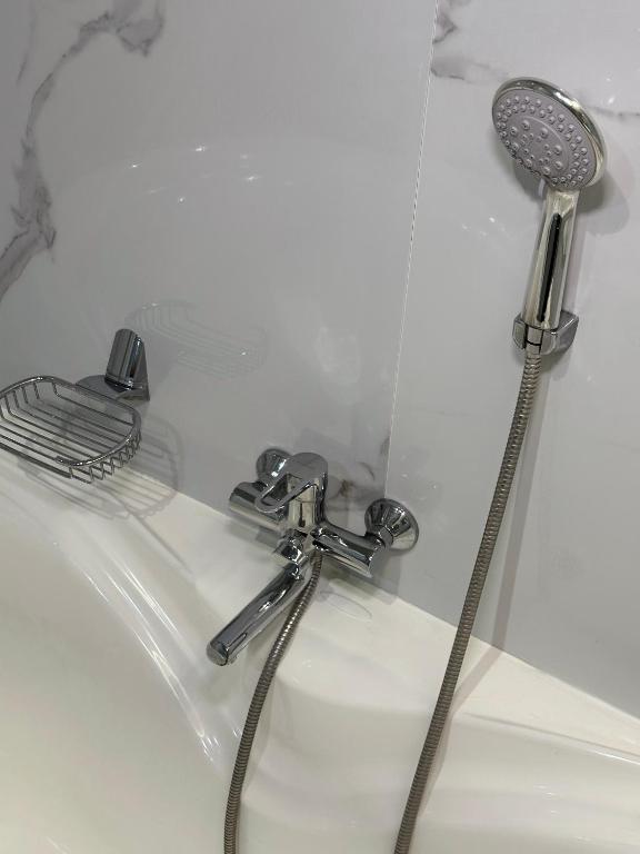 a shower with a shower head and a faucet at PORT INN Hotel in Astana