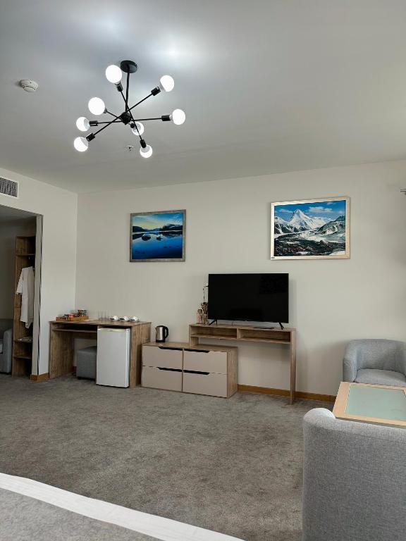 a living room with a flat screen tv and a couch at PORT INN Hotel in Astana