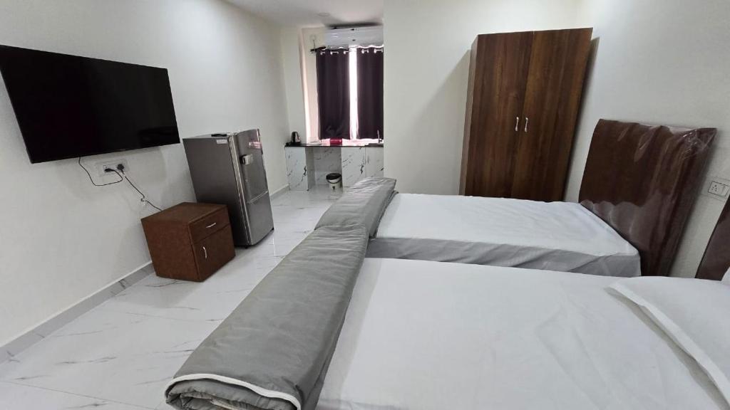 een slaapkamer met 2 bedden en een flatscreen-tv bij Single Suite room in Hyderabad
