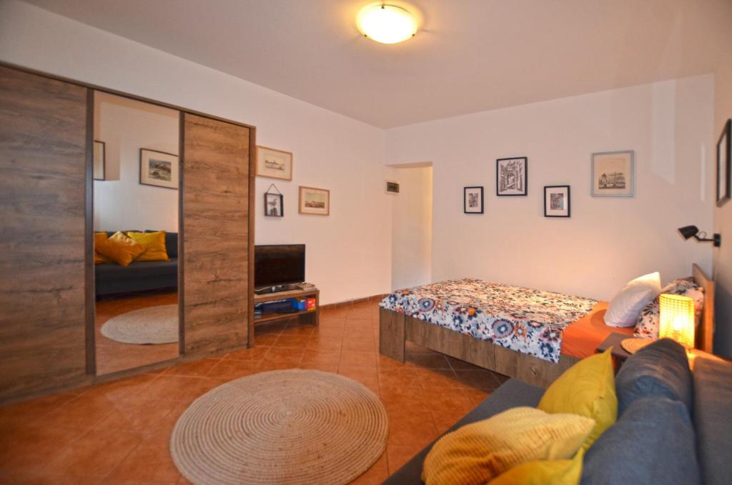 - un salon avec un lit et un miroir dans l'établissement Apartments Greta, à Rovinj