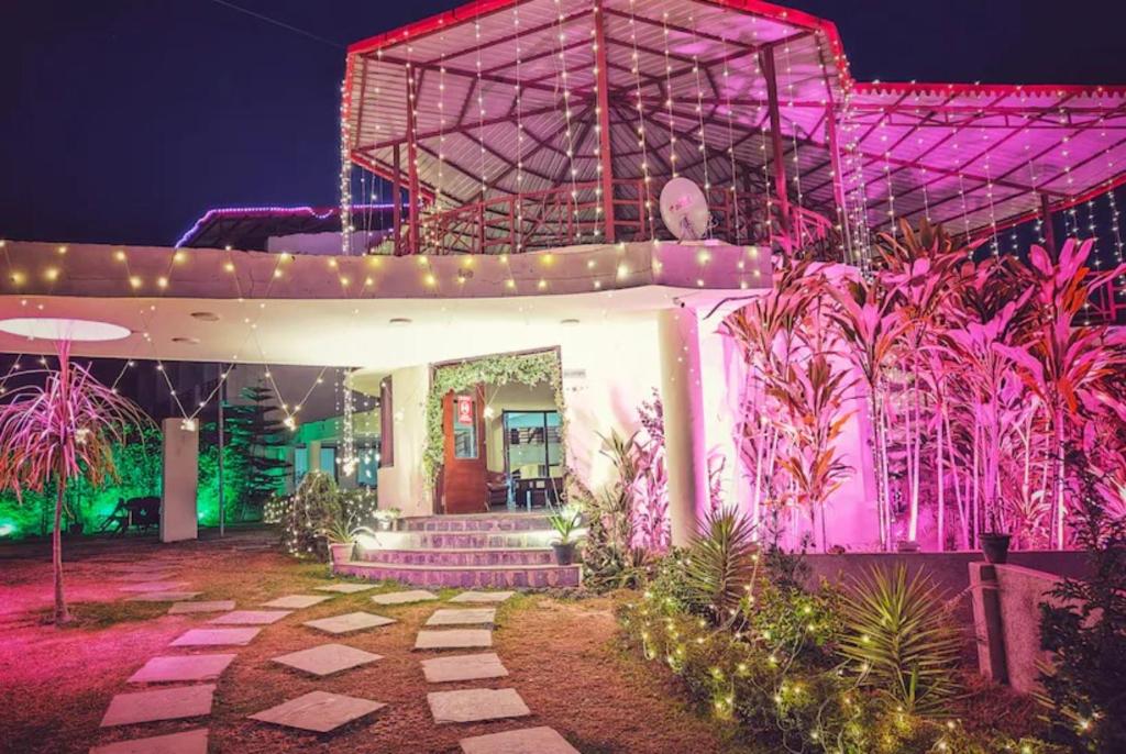una casa con luci rosa sul lato di Hotel Palm Royal Palace Bhimtal a Bhimtal