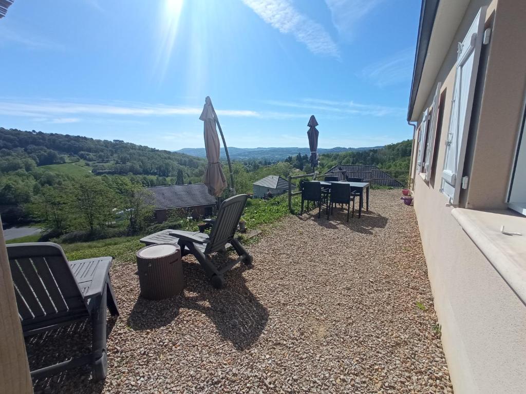 eine Terrasse mit einem Tisch und Stühlen sowie Aussicht in der Unterkunft La Mirabelle 85m2 comfort et très jolie vue in Cublac