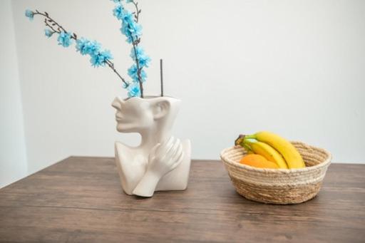 uma estátua branca sentada ao lado de uma cesta de frutas em Hidden Paradise Apartment em Cidade de Kos