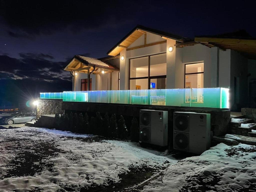 Un bâtiment avec des lumières bleues dans la neige dans l'établissement Къщата на Mечтите / House of the Dreams, à Apriltsi