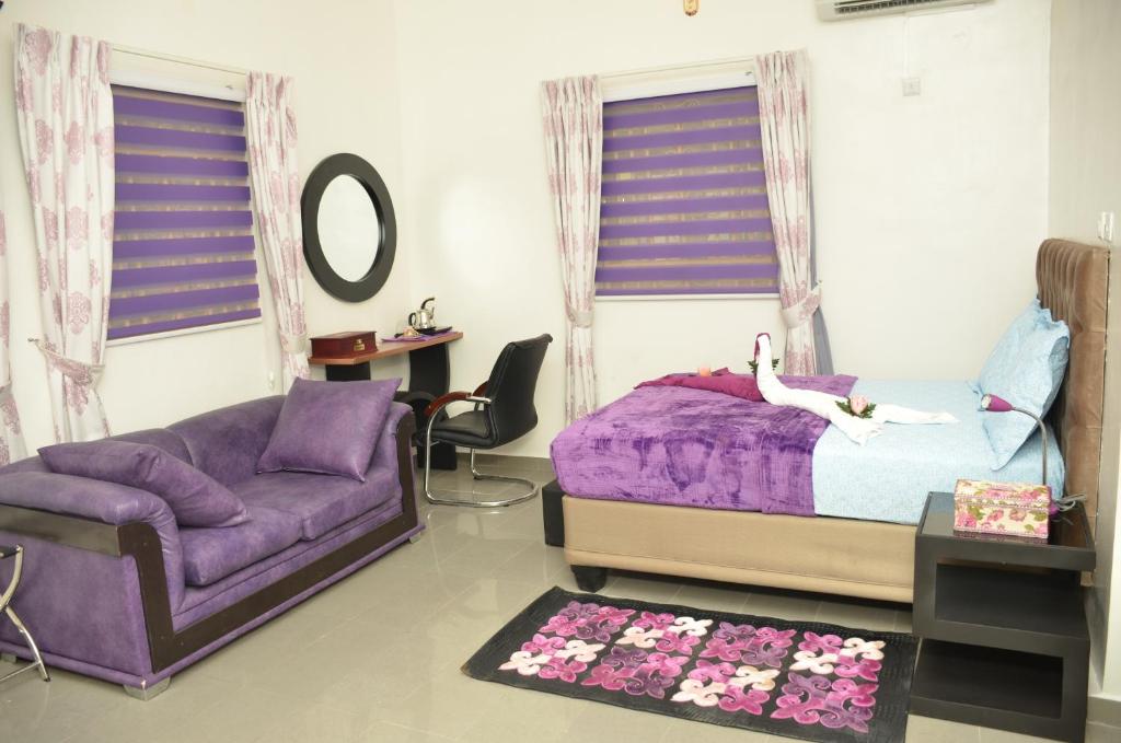 a bedroom with a purple bed and a purple couch at SPA LAVENDER AND SUITES in Port Harcourt
