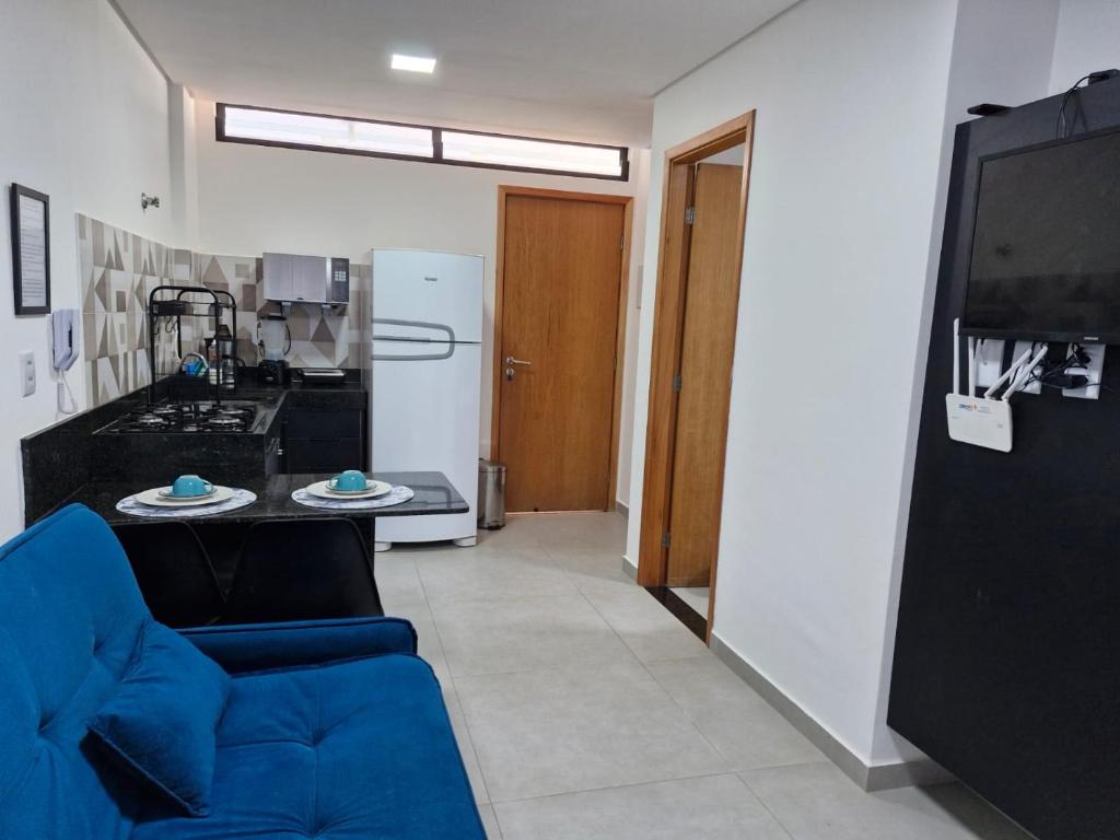 a living room with a blue couch and a kitchen at Maraca Beach I - Flat 102 in Porto De Galinhas
