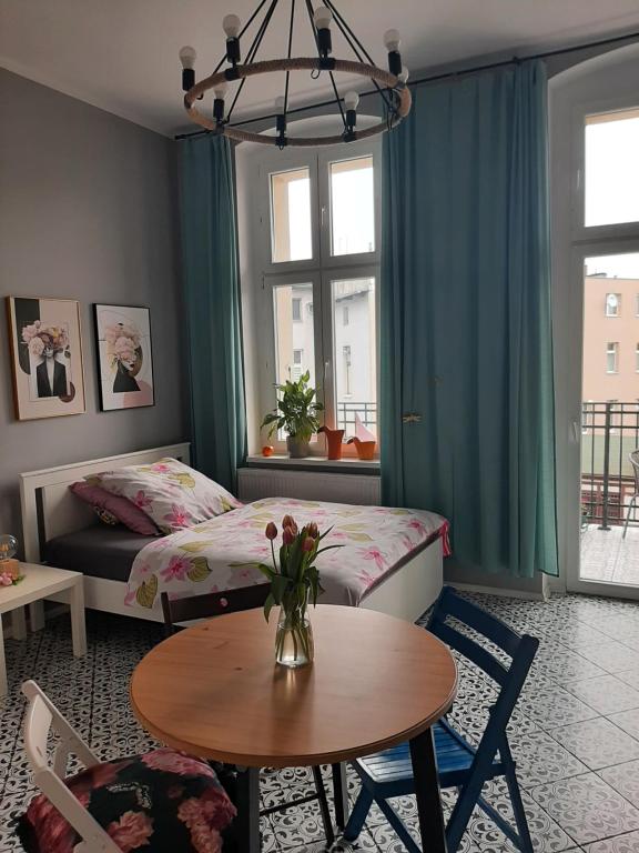 a room with two beds and a table and a table sidx sidx sidx at Apartament u Olechny in Bydgoszcz