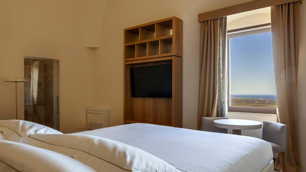 奧斯圖尼的住宿－松米塔城堡酒店，一间卧室设有一张床和一个大窗户