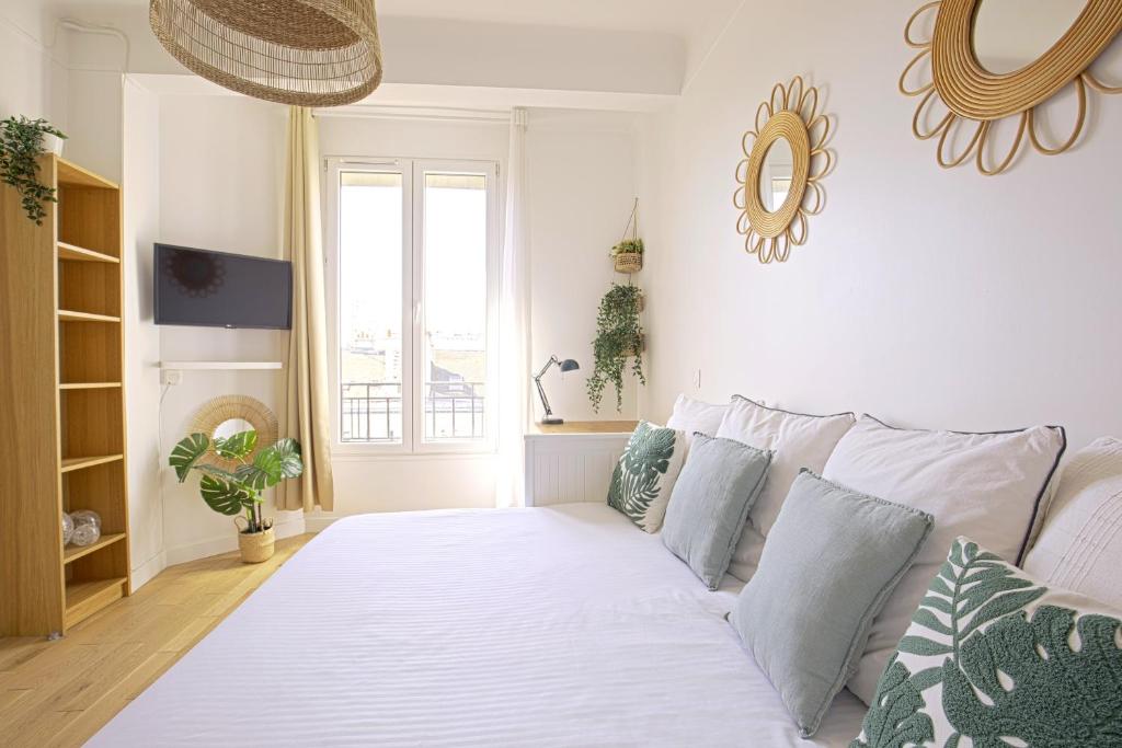 - un salon avec un grand lit blanc et des oreillers dans l'établissement Top floor studio near Montmartre, à Paris