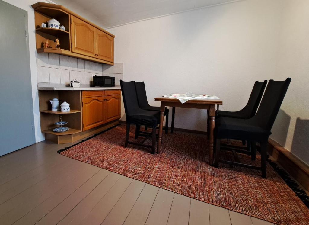 eine Küche mit einem Tisch und Stühlen im Zimmer in der Unterkunft Zum Jagdsteinblick in Bahretal