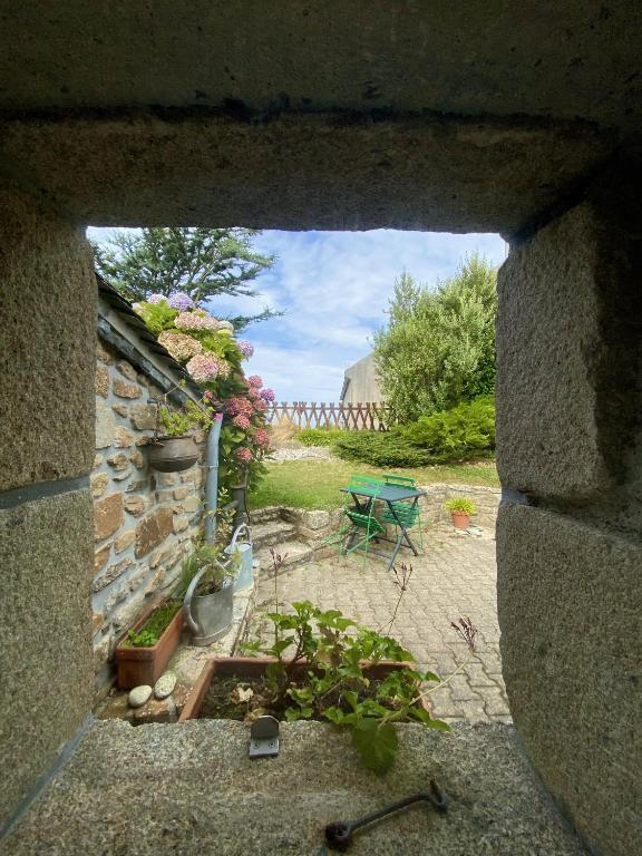 a view of a garden through a stone window at Ty Tour Tan in Plouguerneau