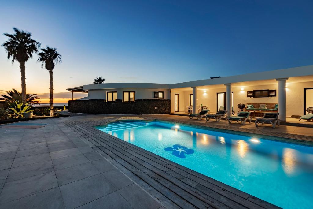 una casa con piscina por la noche en Casa Marina with pool, garden and terrace en Famara