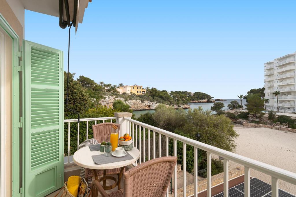 einen Balkon mit einem Tisch und Stühlen sowie Strandblick in der Unterkunft Apartamentos Playa Marina in Cala Ferrera