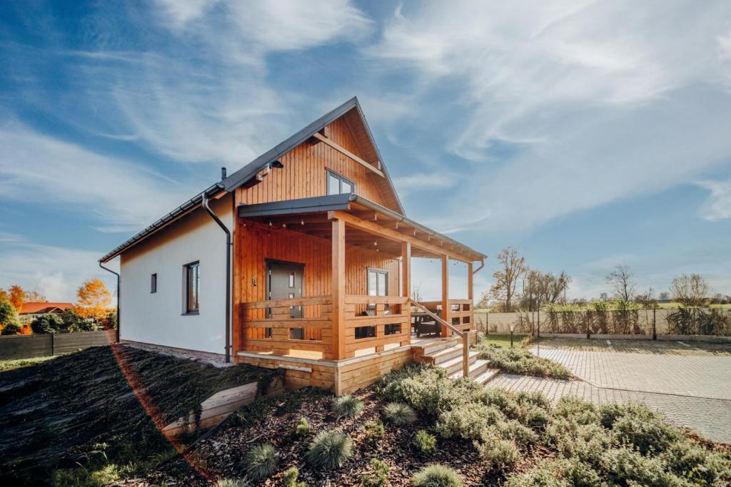 een houten huis met een gambrel dak bij Morze Tu in Stegna