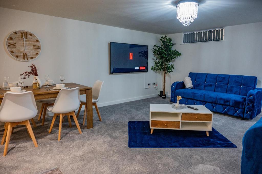 a living room with a blue couch and a table at Basement Bliss Hideaway in Bradford