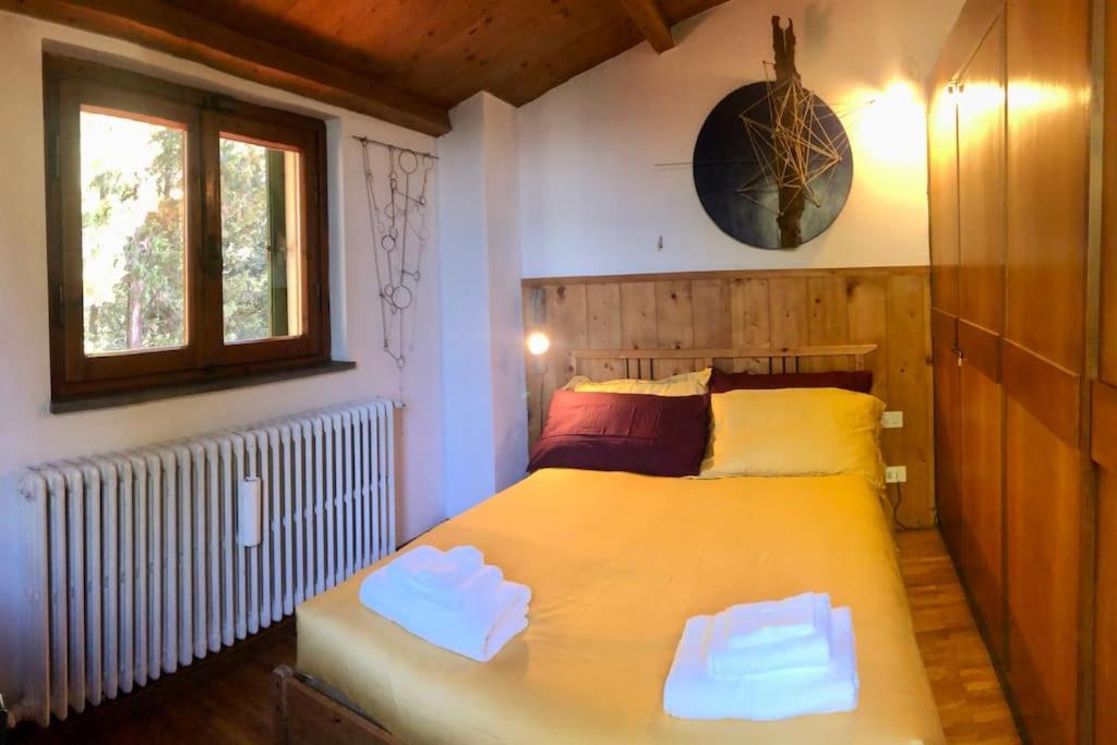 - une chambre avec un grand lit jaune et une fenêtre dans l'établissement La casa di Nello Bini con vista su Firenze, à Bagno a Ripoli