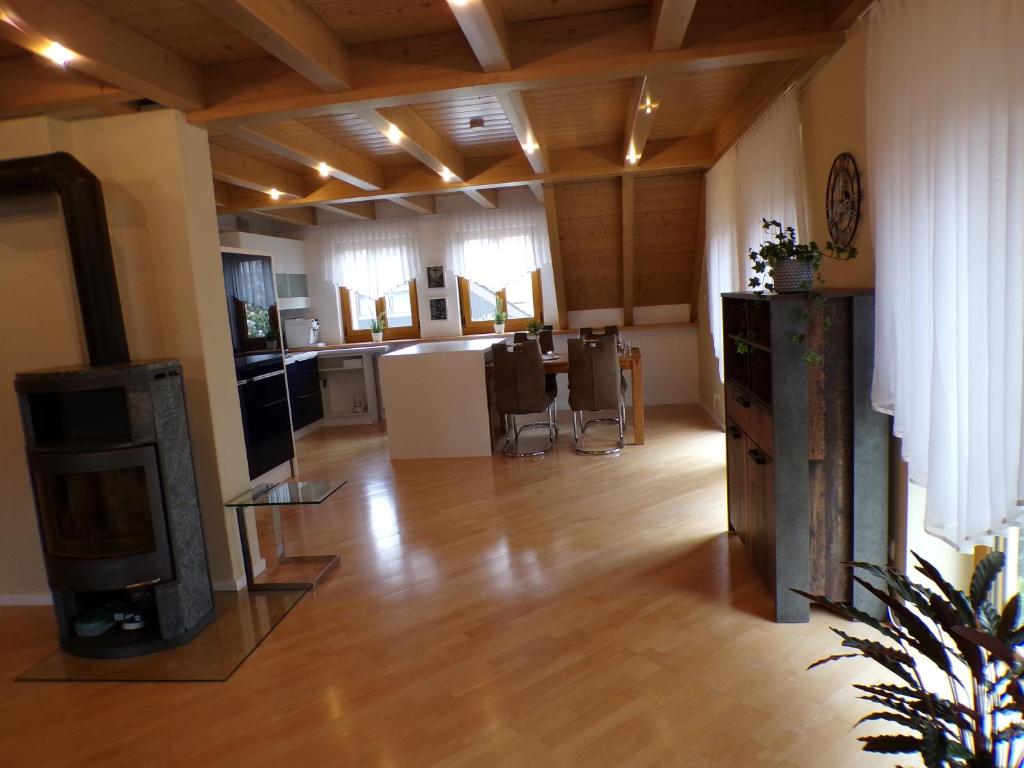 a living room with a hard wood floor and a kitchen at Mondfänger Ferienwohnung , Nähe Playmobil Funpark und Messezentrum in Wilhermsdorf