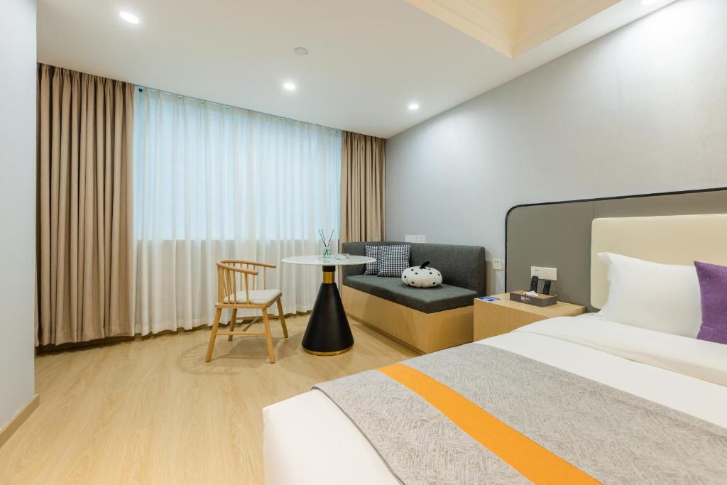 - une chambre avec un lit, une chaise et une table dans l'établissement Roomme私享家东山口地铁站公寓, à Canton