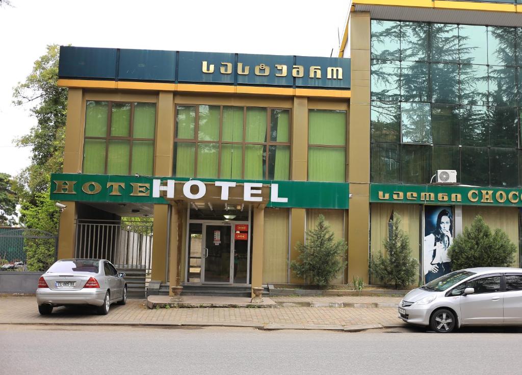 a hotel with two cars parked in front of it at Georgian Paradise in Kutaisi