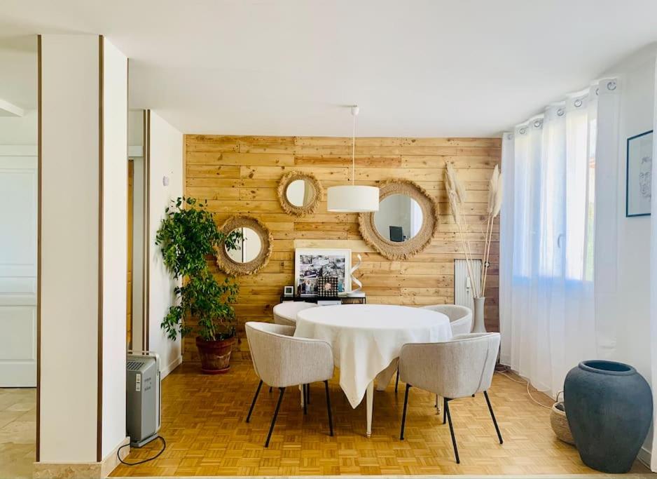 une salle à manger avec une table et des chaises blanches dans l'établissement Spacieux T3 climatisé avec parking proche gare, à Villefranche-sur-Saône