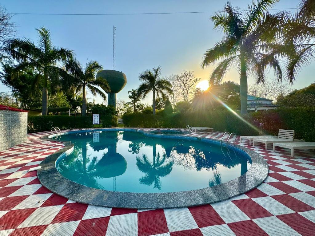 una piscina con palmeras en el fondo en Wanna Stay Corbett, en Belparāo