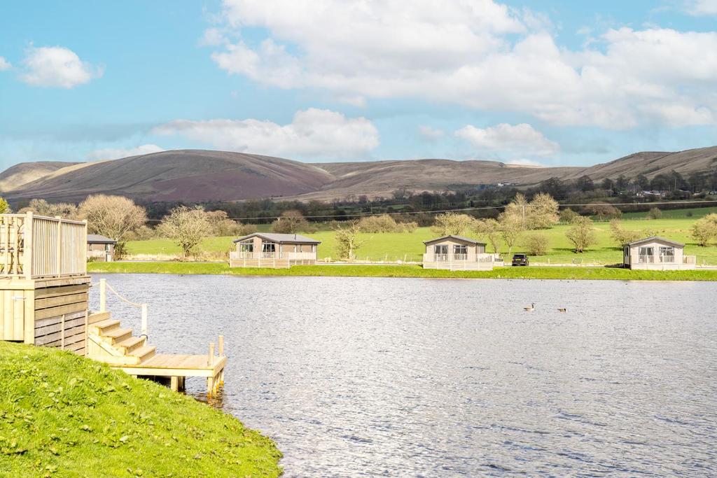 a view of a lake with houses and a dock at Tranquility at Chantry Lodge in Clitheroe