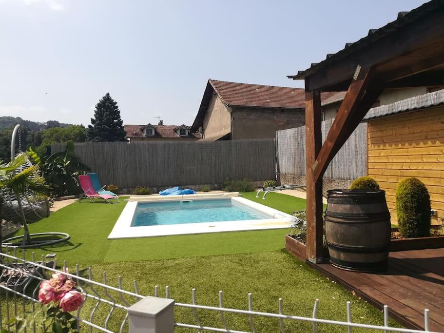 ein kleiner Pool in einem Garten mit einem Zaun in der Unterkunft Appartement + terrasse + piscine in Charavines