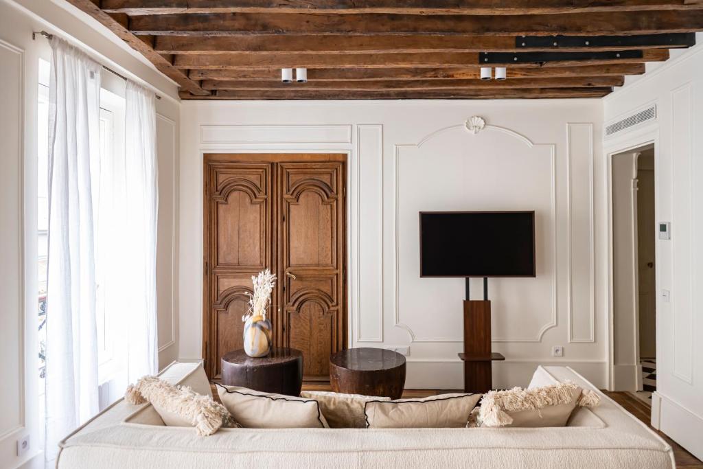 - un salon avec un canapé et une porte en bois dans l'établissement Ile-Saint-Louis apartment, à Paris
