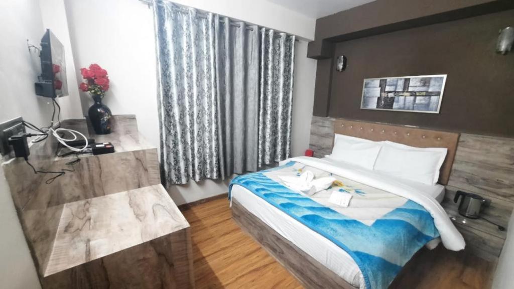 ein Hotelzimmer mit einem Bett und einem Fenster in der Unterkunft Hotel Olive Branch Darjeeling Near Mall Road - Excellent Customer Service - Parking Facilities - Best Seller in Darjeeling