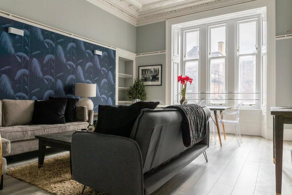 uma sala de estar com um sofá e uma mesa em Beautiful 4 bed flat in perfect central location em Glasgow