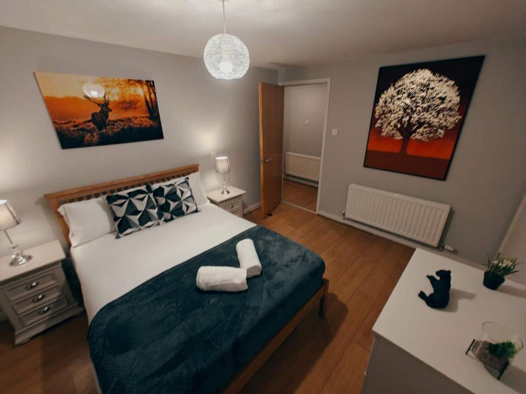 a bedroom with a large bed and a tree on the wall at 2br Cosy City Centre Apartment in Belfast
