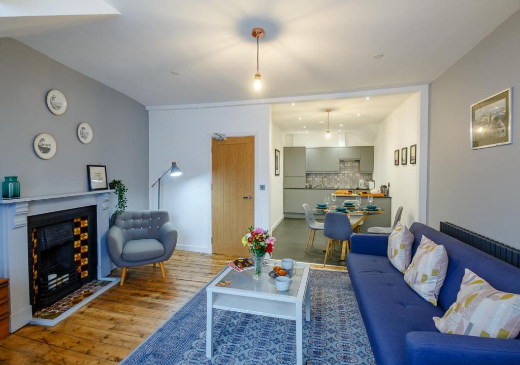 a living room with a blue couch and a fireplace at Fflat Cynan @ Nos Da in Menai Bridge