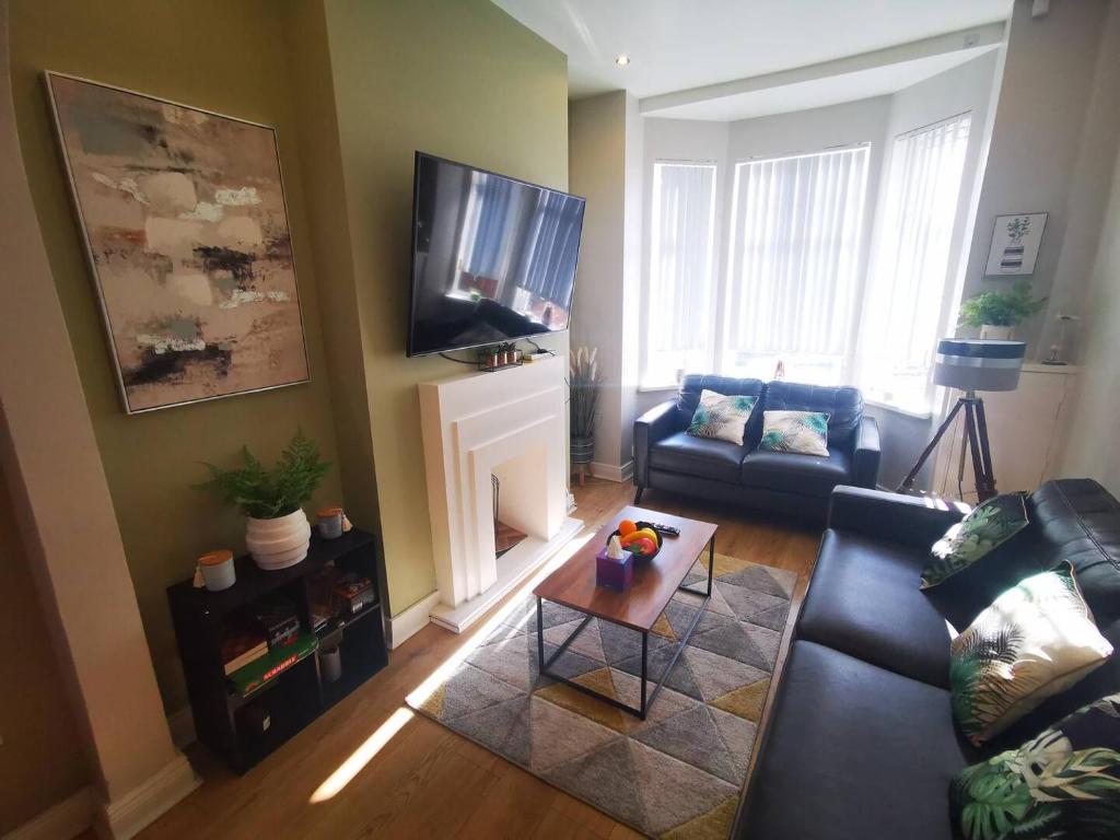a living room with a couch and a tv at 2br Cozy Duplex in Belfast