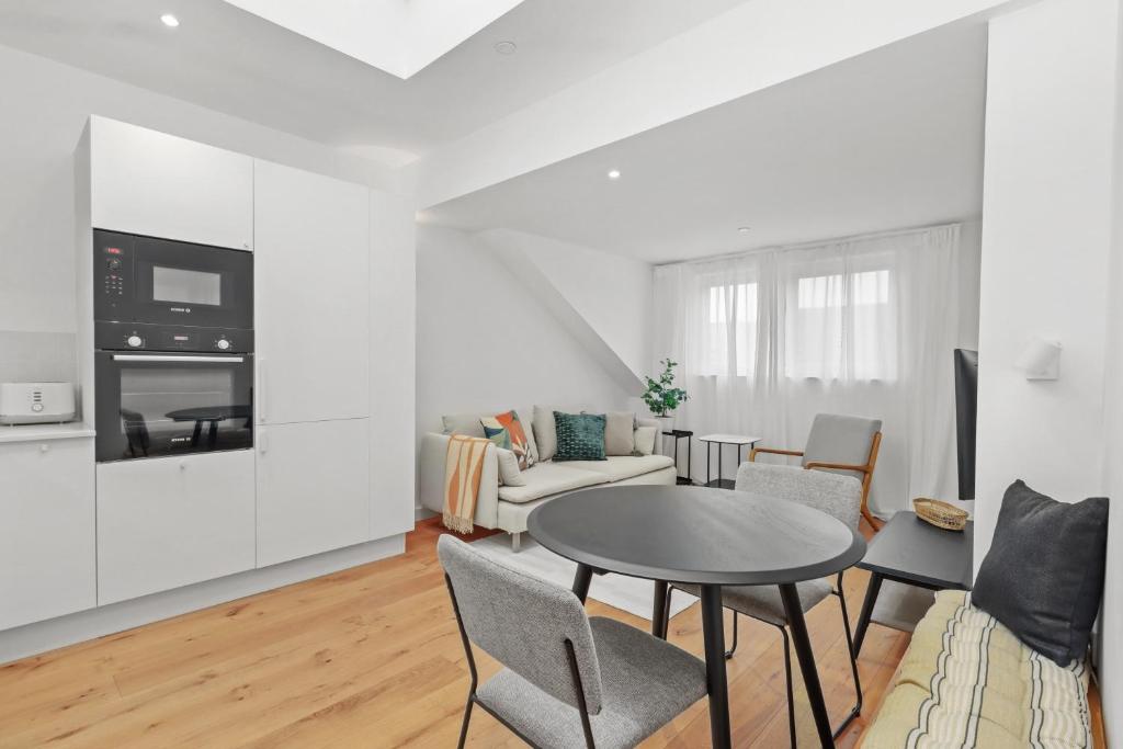 a white living room with a table and chairs at City Sophistication with Coastal Vibes in Eastbourne