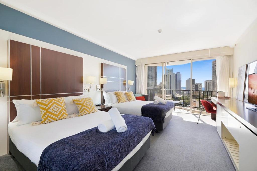 a hotel room with two beds and a balcony at Ocean View Surfers Paradise Studio Close to Beach in Gold Coast