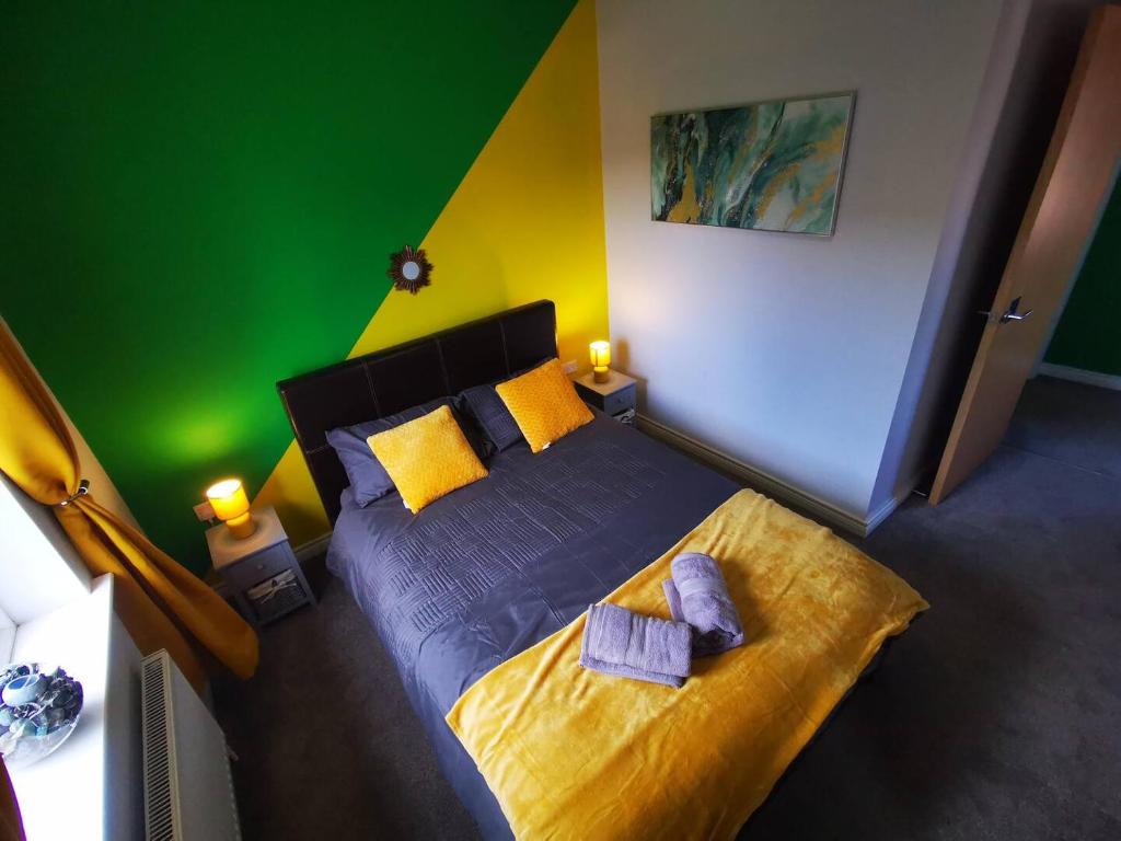 a bedroom with a bed with yellow and green walls at 3br Cosy Modern Stay in Belfast