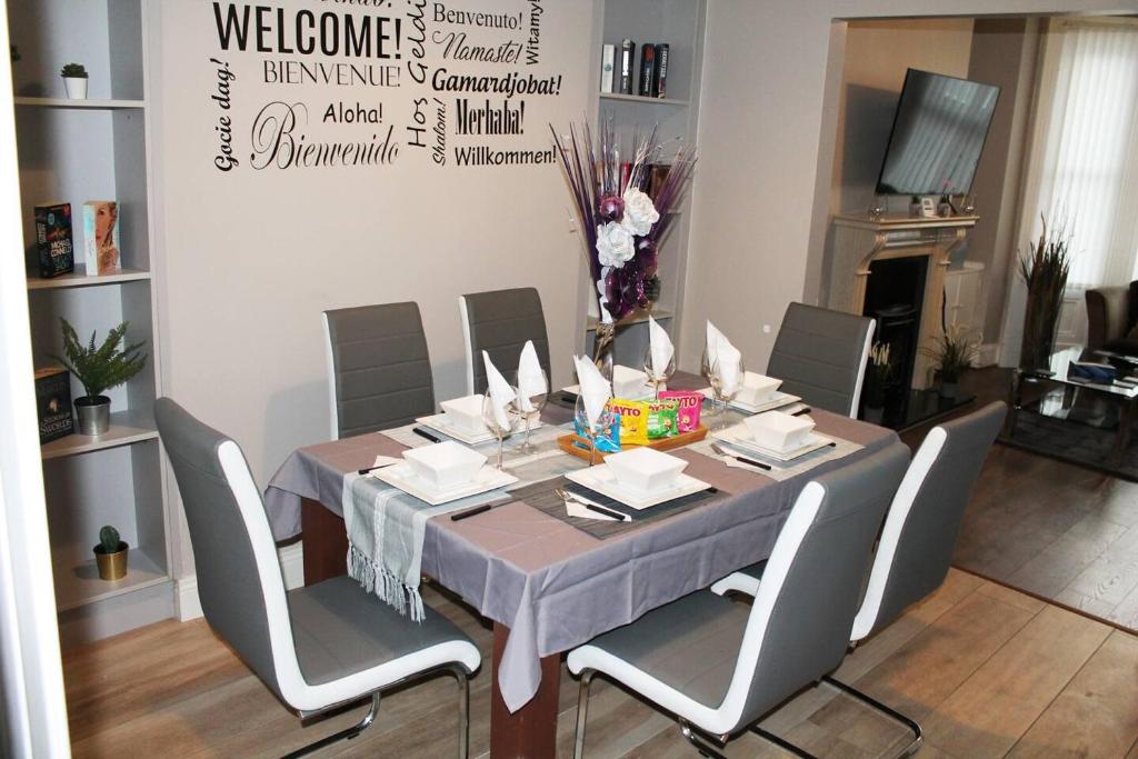 uma sala de jantar com mesa e cadeiras em 4 Bed Boutique House Lisburn Road em Belfast