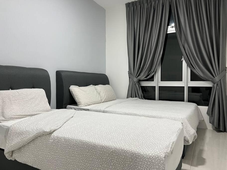 a room with two beds and a couch and a window at Ipoh Town Anderson Hana Suite 7 paxs 2R2B in Ipoh