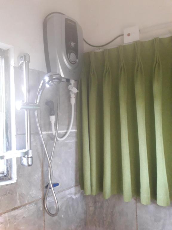 a shower in a bathroom with green curtains at WATHSALA HOME VILLA(homestay) in Ella
