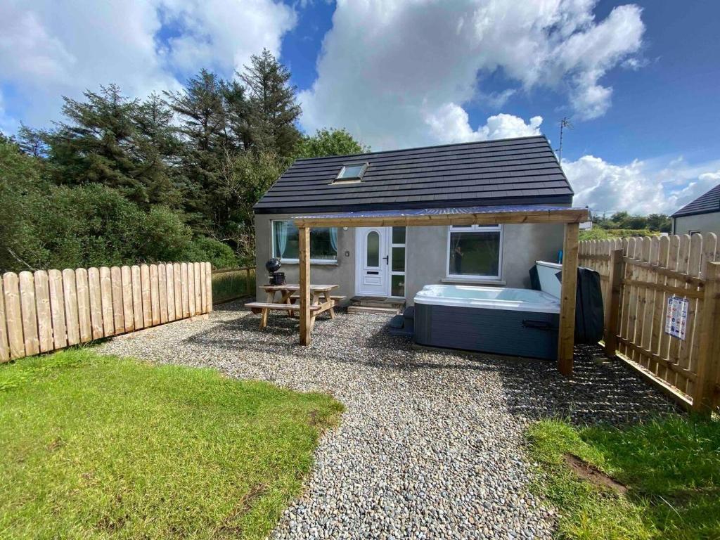 a small shed with a bed in a backyard at Forest View Cottage - Private Hot Tub in Ballynameen