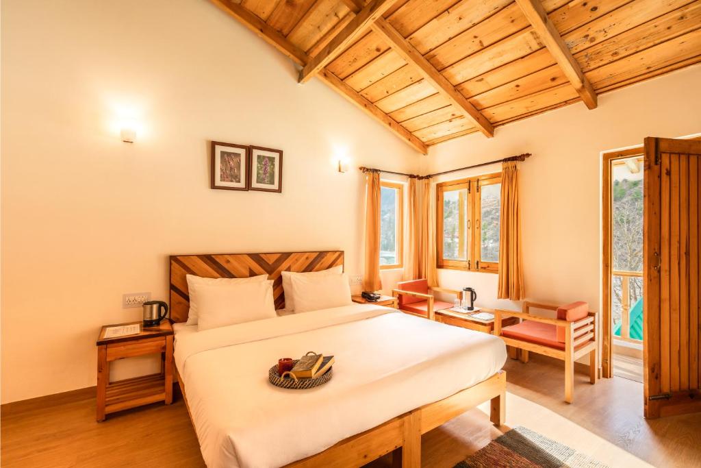 a bedroom with a bed and a table and chairs at Prakriti-The Retreat in Gangotri