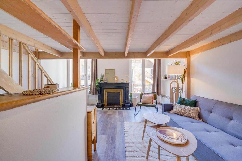 un salon avec un canapé bleu et une table dans l'établissement L'Hironda - Appt pour 2 - Quartier Saint-Pierre, à Bordeaux